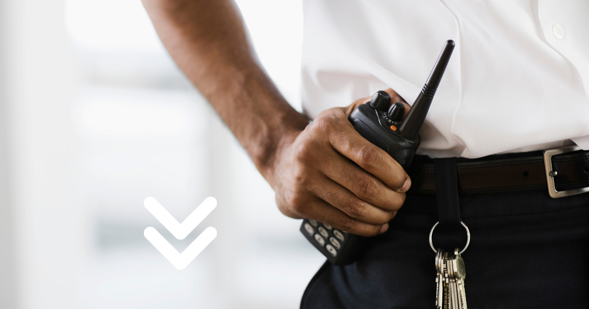 Security professional holding a walkie-talkie with their hand